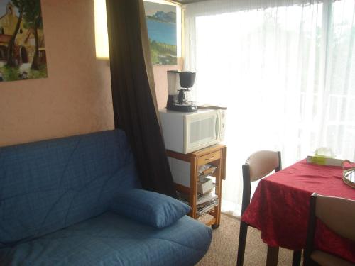 un salon avec un canapé bleu et un four micro-ondes dans l'établissement la meridienne, à Sète
