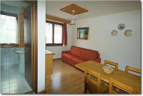 a living room with a red couch and a table at Cornostella in Foppolo