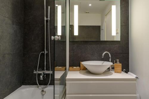 La salle de bains est pourvue d'un lavabo et d'une douche. dans l'établissement APG Mercaders 6, à Gérone