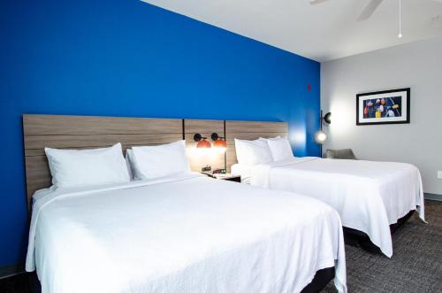 2 camas en una habitación de hotel con paredes azules en The Place at Port Aransas, en Port Aransas
