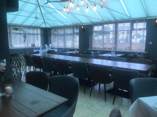 a dining room with tables and chairs and windows at The Reubens in Bedale