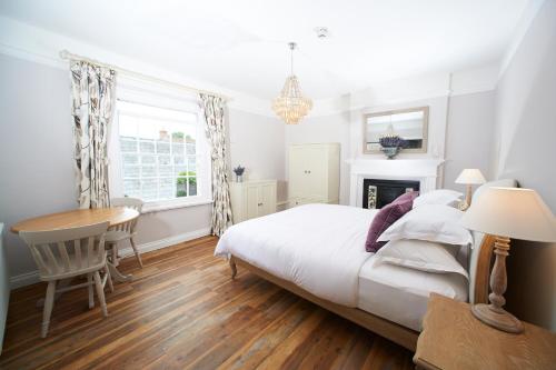 a bedroom with a bed and a desk and a table at The Bugle Inn Twyford in Winchester