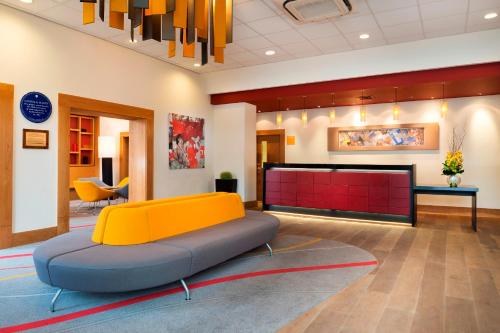 a waiting room with a yellow and blue couch at Park Inn by Radisson Palace in Southend-on-Sea