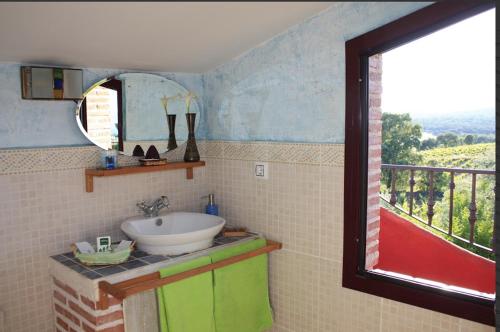a bathroom with a sink and a large window at Las Casas De "El Cerrillo" in Montesclaros