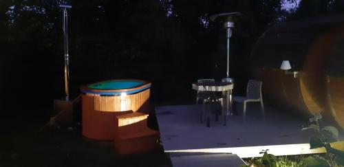a lit up backyard at night with a table and chairs at Tonn"O Loisirs in Servel