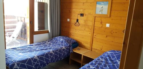 een slaapkamer met 2 bedden, een bureau en een raam bij L'Ours Blanc in Huez