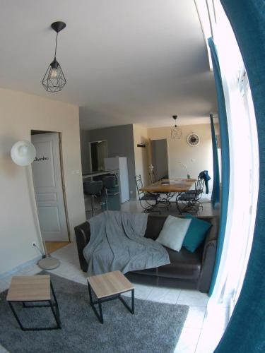 ein Wohnzimmer mit einem Sofa und einem Tisch in der Unterkunft Au bonheur des Anes - Gîte Idylle in Le Quesnoy-en-Santerre