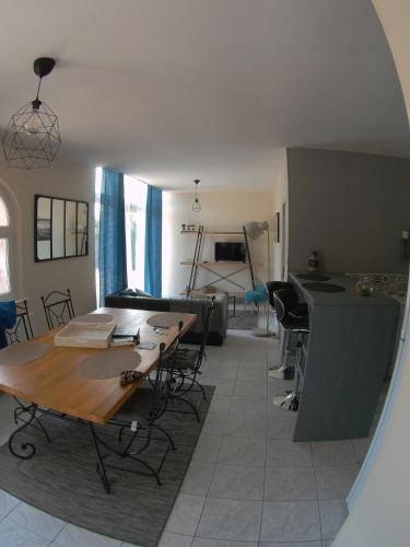 ein Wohnzimmer mit einem Tisch und einem Sofa in der Unterkunft Au bonheur des Anes - Gîte Idylle in Le Quesnoy-en-Santerre