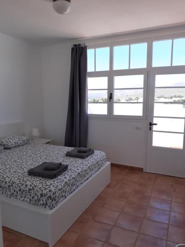 een slaapkamer met een bed met twee handdoeken erop bij Casa Mi Sol in Puerto Calero