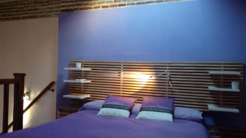 Schlafzimmer mit einem Bett mit lila Wänden und Kissen in der Unterkunft COSY DOUBLE ROOM + PRIVATE BATHROOM SEVILLA CENTER in Sevilla
