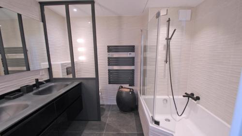 une salle de bain avec un lavabo, une baignoire et une douche dans l'établissement Les Terrasses de la Croisette, à Sainte-Maxime