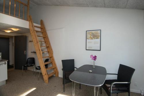 a room with a table and chairs and a ladder at Ebeltoft Feriecenter in Ebeltoft