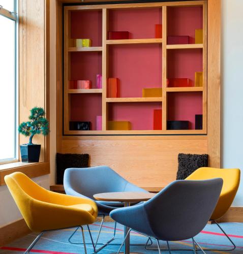 a room with chairs and a table and shelves at Park Inn by Radisson Palace in Southend-on-Sea