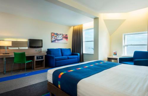 a hotel room with a bed and chairs and a desk at Park Inn by Radisson Palace in Southend-on-Sea