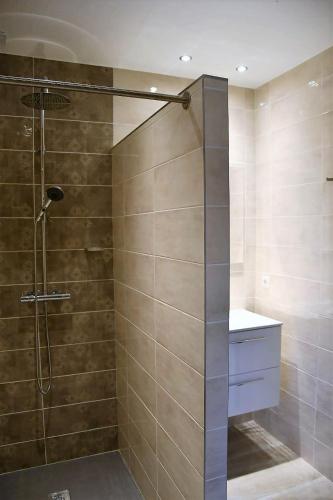 une douche avec une porte vitrée dans une salle de bain dans l'établissement Cosy vue mer, à Olmeto