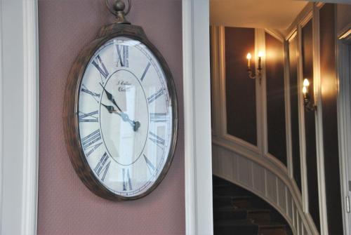 a clock hanging on a wall in a hallway at Logis Hôtel de l'Europe in Poitiers
