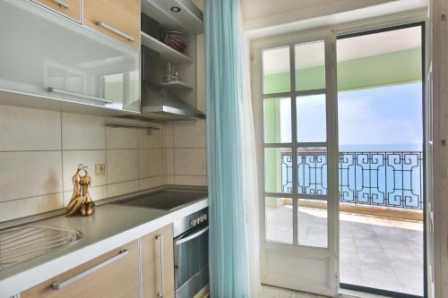 cocina con ventana y vistas a un balcón en Montesan Beach Apartments Sveti Stefan, en Sveti Stefan