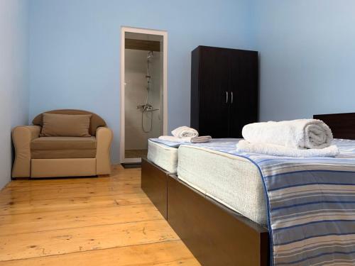 una camera con due letti, un divano e una sedia di Guest house lela a Mestia