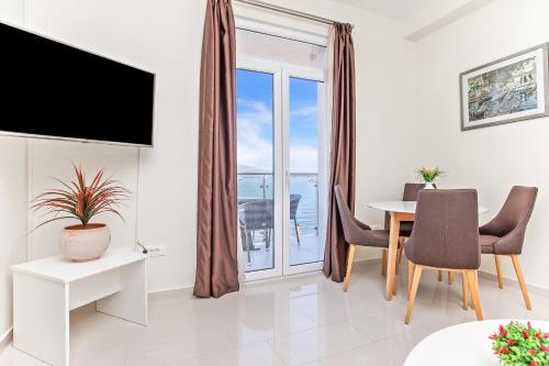 a living room with a dining table and a television at Apartments Isja in Tivat