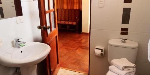 クスコにあるクスカ ホスタルのバスルーム(白い洗面台、トイレ付)
