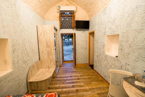 un pequeño pasillo de la casa con un banco y una ventana en Boutique Hotel Minzifa, en Bukhara