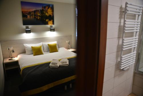a bedroom with a bed with two slippers on it at Centrum Restauracyjno-Hotelowe Florres in Pawłowiczki