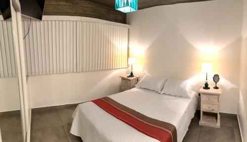 ein Schlafzimmer mit einem Bett mit zwei Nachttischen und zwei Lampen in der Unterkunft Departamento - Edificio Los Naranjos in San Salvador de Jujuy