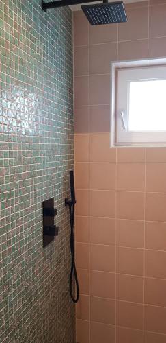 a shower with a phone and a window in a bathroom at JaBaKi Green Studio in Hoofddorp