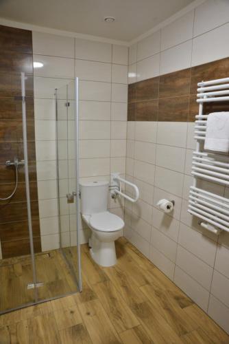 a bathroom with a toilet and a glass shower at Centrum Restauracyjno-Hotelowe Florres in Pawłowiczki