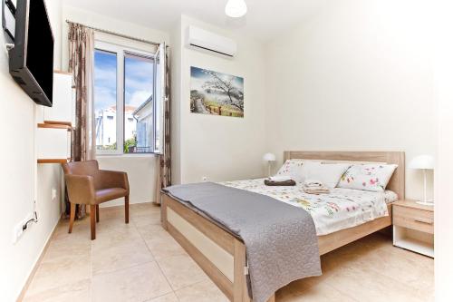 a bedroom with a bed and a tv and a window at Apartments Isja in Tivat