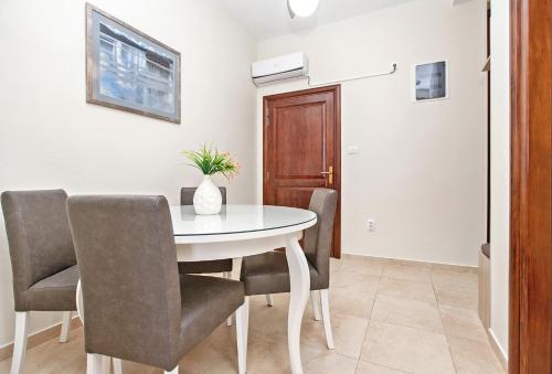 a dining room with a white table and chairs at Apartments Isja in Tivat