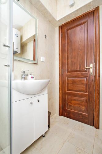 a bathroom with a sink and a wooden door at Apartments Isja in Tivat