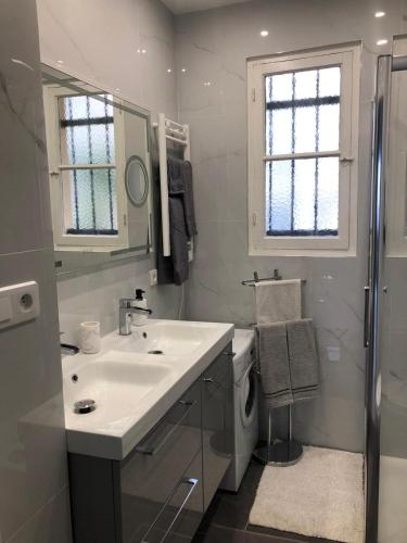 une salle de bain blanche avec un lavabo et une douche dans l'établissement Stella Apartment, à Beausoleil