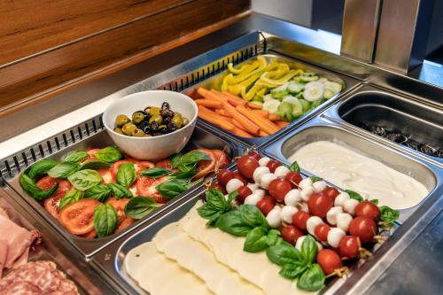 a buffet with many different types of vegetables and cheese at Hotel Meridiana in Malcesine