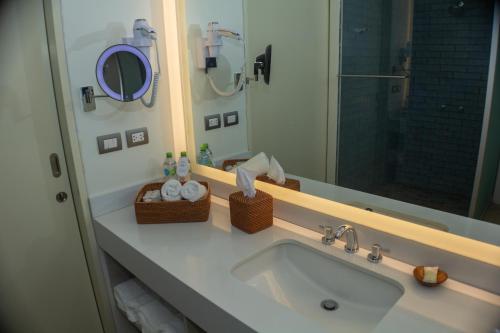 a bathroom with a sink and a mirror at Punta Sal Suites & Bungalows Resort in Canoas De Punta Sal