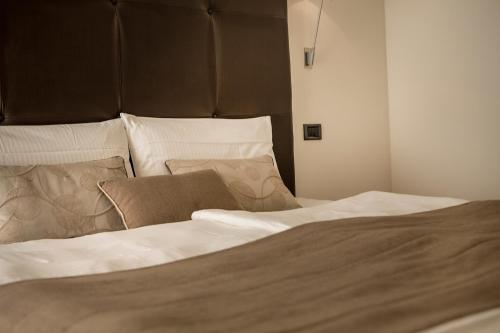 a bedroom with a bed with white sheets and pillows at Hotel Meridiana in Malcesine