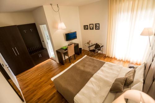Dormitorio con cama, escritorio y TV en Hotel Meridiana, en Malcesine