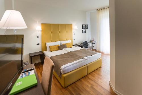 a bedroom with a large bed and a desk at Hotel Meridiana in Malcesine