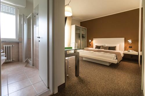 a bedroom with a large bed and a bathroom at Hotel Meridiana in Malcesine
