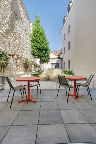 a patio with two tables and chairs in a courtyard at ibis Saint Germain en Laye Centre in Saint-Germain-en-Laye
