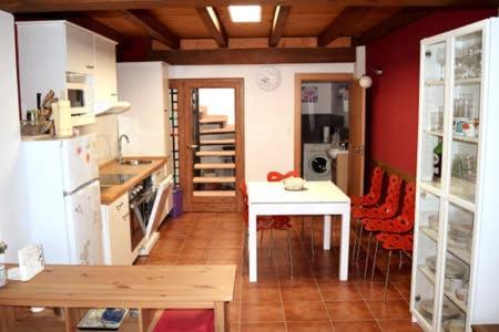 uma cozinha com uma mesa branca e um frigorífico branco em Casita de la Plaza . VUT-47-172 em Sardón de Duero