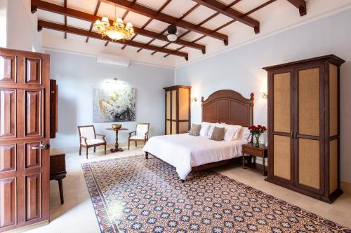 a bedroom with a bed and a table and chairs at Casa Tavera- Adults Only in Mérida