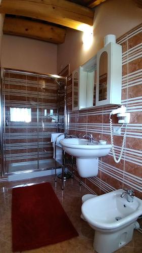 a bathroom with three sinks and a mirror at Agriturismo Al Casale in Lonigo