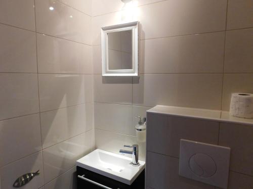 a white bathroom with a sink and a mirror at Villa Renata - Apartment Bijeli in Povlja