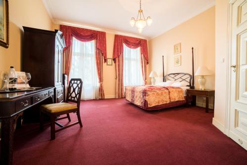 a bedroom with a bed and a desk and a chair at Pałac Bielawa in Bielawa