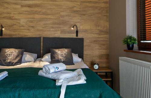 sypialnia z zielonym łóżkiem i ręcznikami w obiekcie Apartament MOUNTSEA ,Karpacz Ogrodnicza w mieście Karpacz