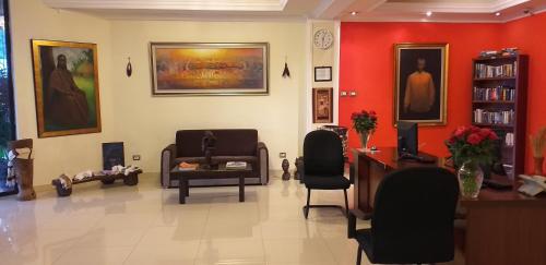 a waiting room with chairs and paintings on the walls at Sidama Inn in Addis Ababa