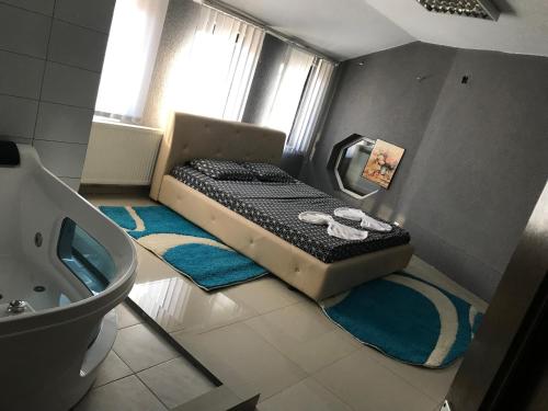 a small bedroom with a bed and a tub at Hotelwhite Family Gjilan in Gjilan