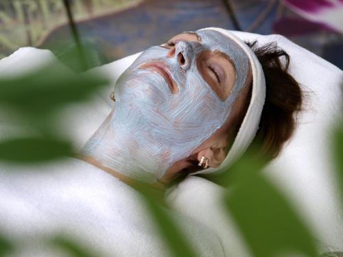a woman with a mask on her face on a towel at Hotel An der Brunnader - Die Therme befindet sich 4 Geh-Minuten entfernt in Bad Birnbach