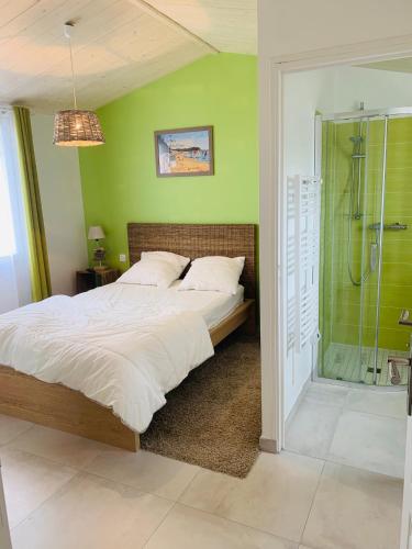 une chambre avec un grand lit et une douche dans l'établissement La désirée, à Noirmoutier-en-l'lle